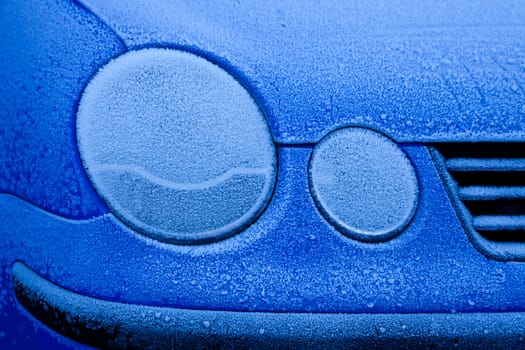 Ice on a blue car during winter season, good for concepts