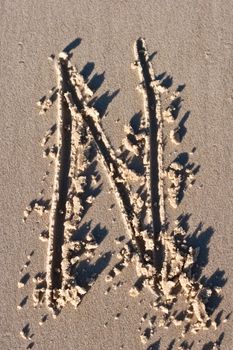 Letter N drawn in the sand. 