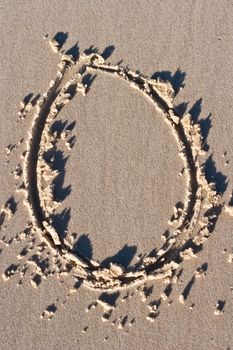 Letter O drawn in the sand. 