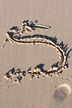 Letter S drawn in the sand. 