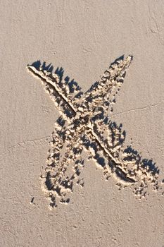 Letter x drawn in the sand.