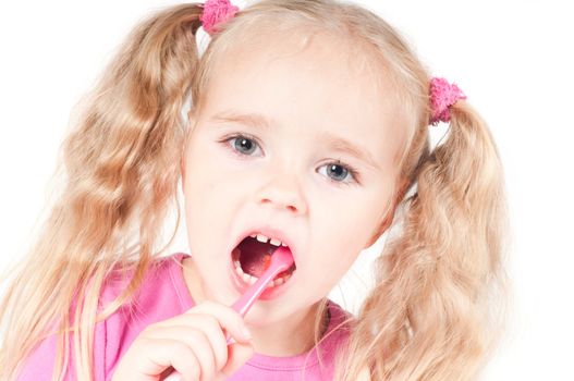 Little cute girl in pink and with ponytails in studio