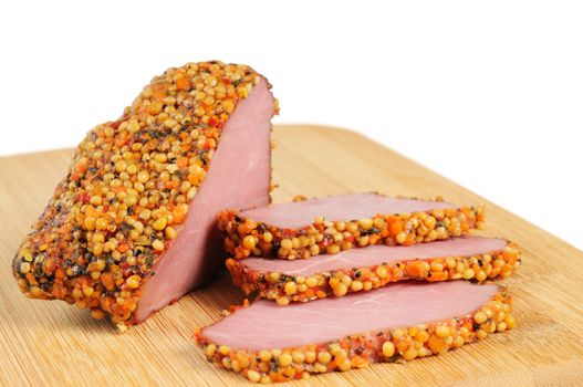 Piece of a ham with spices on a wooden board. Onwhite background.