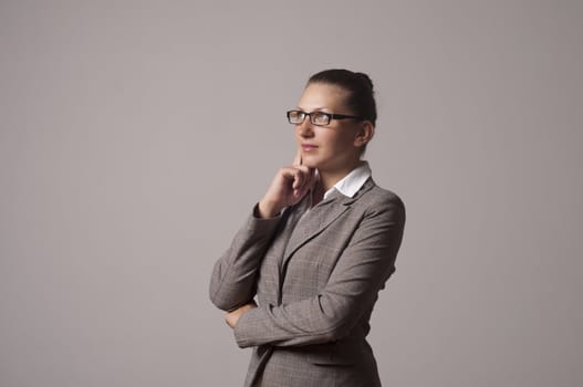 portrait of a young successful woman, looks up and thinks