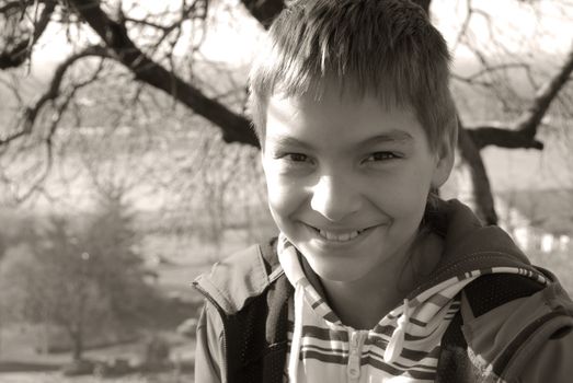 portrait of teenage caucasian smiling boy outdoor in black and white