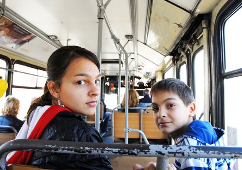 teenage girl and boy portrait looking over shoulder in city bus
