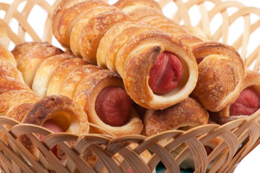 Sausage rolls in pastry in a wicker basket