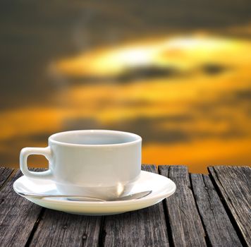Coffee cup on the wooden table with sunset  sky background