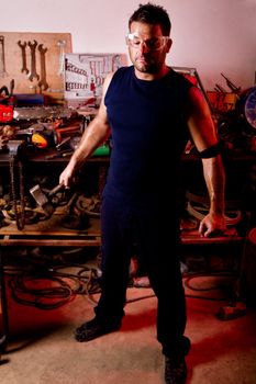 View of a garage mechanic man holding a hammer.