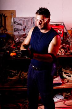 View of a garage mechanic man putting some protective gloves.