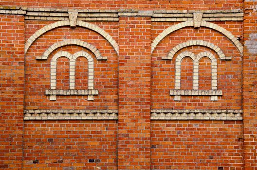 Red brick wall with window imitation made of white bricks.