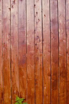 Wall of narrow brown painted planks. Wooden architectural background.