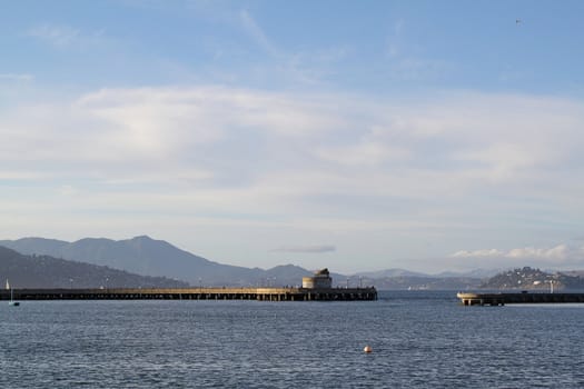Seascape with a pier and mountains on background