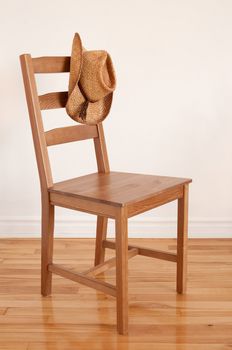 Colors of natural wood. Chair on wooden floor and cowboy hat.