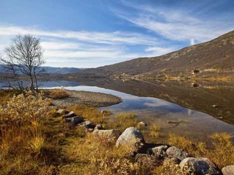 Peacefull lake, bare trees and autumn colors at Haukeli, Norway