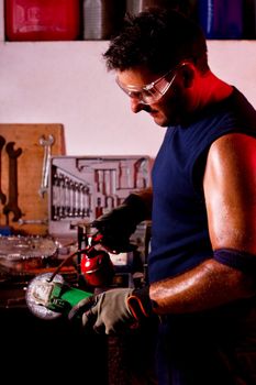 View of a happy garage mechanic man holding a oil can.