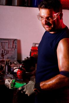 View of a happy garage mechanic man holding a oil can.