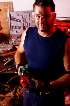 View of a happy garage mechanic man holding a oil can.