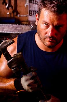 View of a garage mechanic man holding an adjustable spanner.