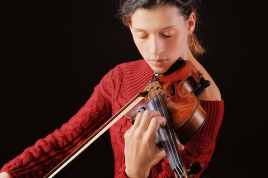 A young woman playing a violin with expression