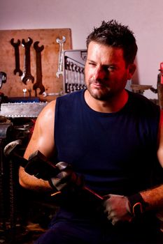 View of a garage mechanic man holding an adjustable spanner.