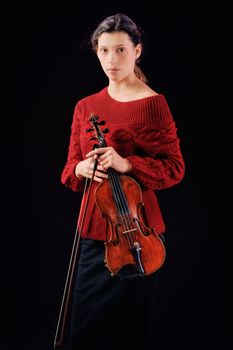 Young woman holding a violin. Isolated on the black background