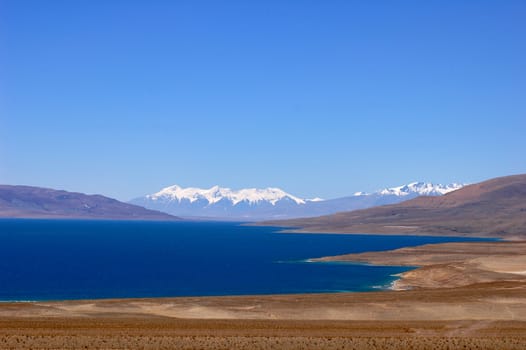 Landscape of blue lake and snow covered mountains in the highlands of Tibet