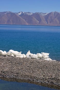 Landscape of blue lake and snow covered mountains in the highlands of Tibet