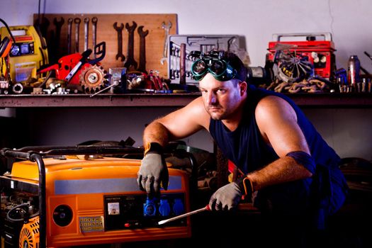 View of a garage mechanic man holding a screwdriver.