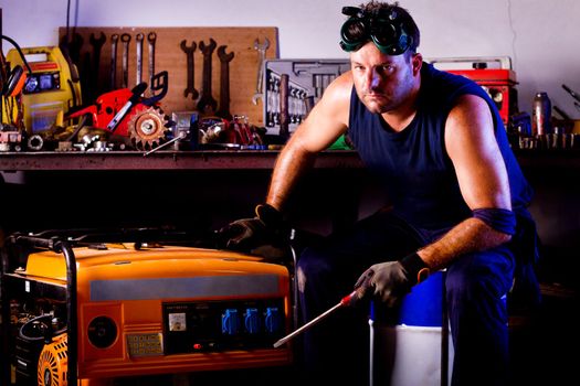 View of a garage mechanic man holding a screwdriver.