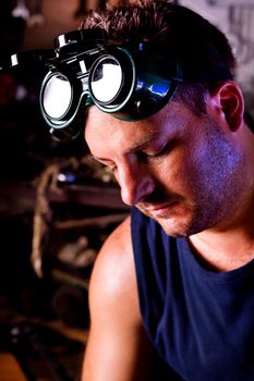 View of a garage mechanic man face with protection goggles.