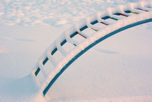 Playground in winter morning covered with snow