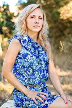 View of a beautiful young girl with a blue dress on the forest.