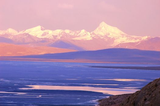 Landscape of blue lake and snow mountains at sunrise
