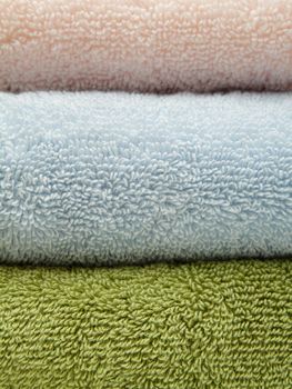 Stack of three bath towels of different colors