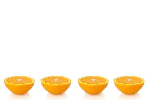 Four small orange halves arranged in a horizontal line along the bottom of the image and over white.