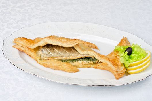 tasty dish of trout fish baked with greens at dough