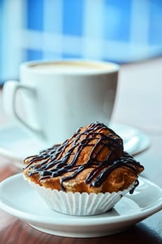 Chocolate muffins with and coffee cup on orange table