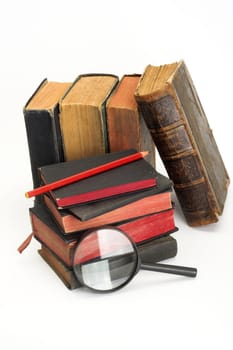 stack of old books and magnifier, close up
