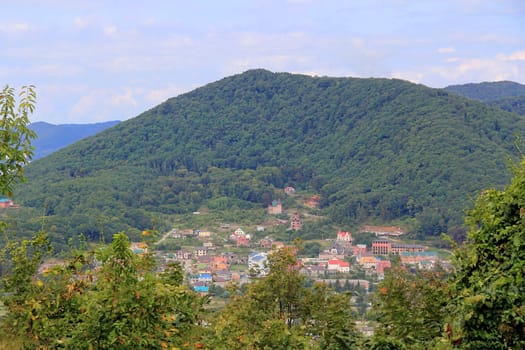 Summer landscape with Caucasus mountains and small town