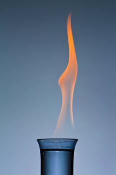 Shot glass with a clear liquid of fire with flames showing
