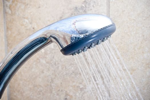 A photograph of a shower head with water coming out of it. Water is an important natural resource.