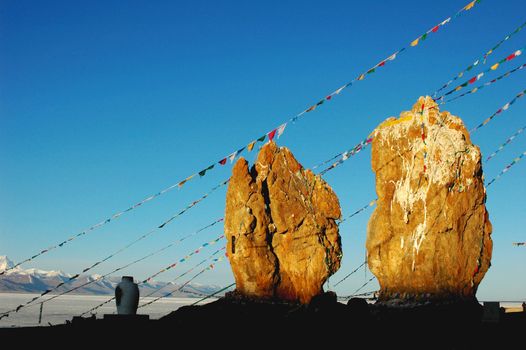 Huge rocks with colorful prayer flags at lakeside 