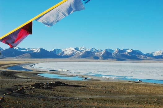 Landscape of snow mountains and frozen lake in the highlands of Tibet in the early spring