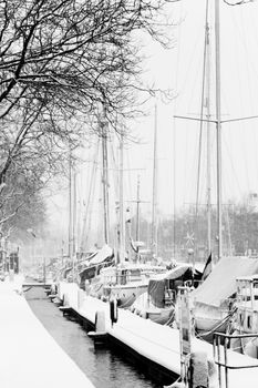Yachts in harbor with winter ice and snow - black and white image