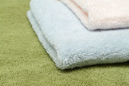 A stack of three bath towels of different colors