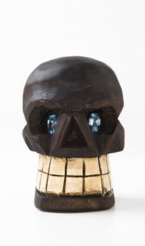two oval cut blue topaz set within a wooden skull