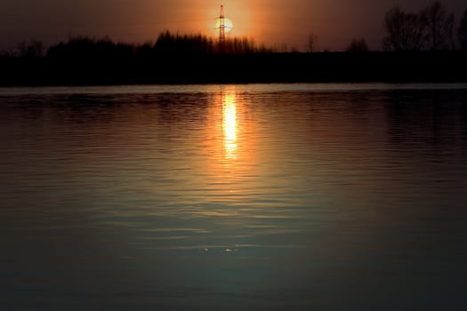 Kind on the river in the evening and a sunset