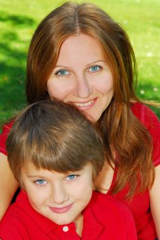 Portrait of smiling mother and son in summer park