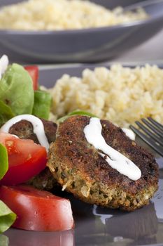 Falafel with yogurt sauce with tomatoes, lettuce and bulgur.